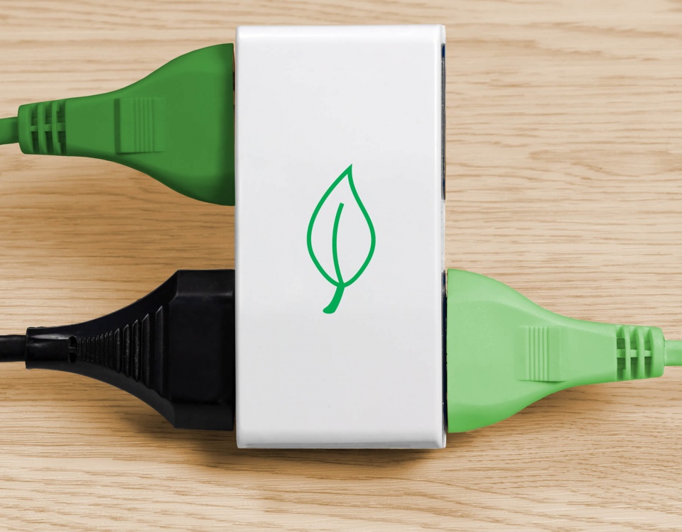 A white eco-friendly power bar with black and green plugs attached